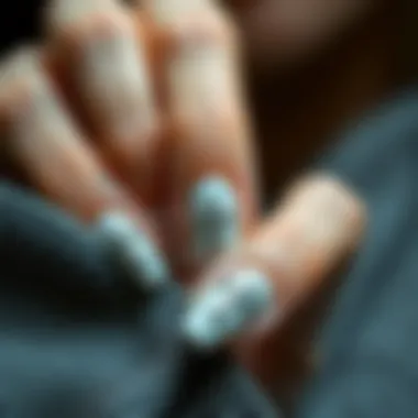 Trendy nail art incorporating silver cross nail charms for a modern look.